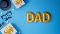 Top View of Golden Balloony DAD Text with Gift Box and Male Hipster Elements Decorated Blue Strips Background for Father