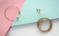 Top view of golden bracelets and ring on pastel colors papers background