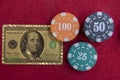 Top view of golden 100 dollar playing cards next to stacks of chips on red felt table Royalty Free Stock Photo