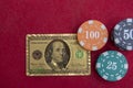 Top view of golden 100 dollar playing cards next to stacks of chips on red felt table Royalty Free Stock Photo
