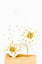 Top view of golden dotted gift boxes, a shopping bag and star shaped golden confetti on a white background. Copy space Royalty Free Stock Photo
