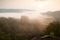 Top view, golden sunrise shines down around the mist and evergreen forest. Thai-Laos border. Na Haeo, Loei, Thailand. Winter