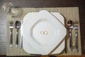 Top view of golden wedding rings on a white plate on a wooden table Royalty Free Stock Photo