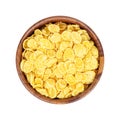 Top view of golden yellow crunchy corn flakes cereal in a round wooden bowl isolated on white background. Royalty Free Stock Photo