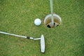 Top view of a golf ball with putter on green course at hole Royalty Free Stock Photo