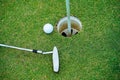 Top view of a golf ball with putter on green course at hole. Golf ball and golf club on green in the evening golf course with Royalty Free Stock Photo