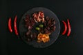 top view of gourmet assorted meat with olives on slate board and chili peppers