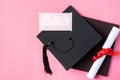 Graduation academic cap with diploma and mask isolated on pink table background Royalty Free Stock Photo