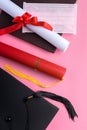 Graduation academic cap with diploma and mask isolated on pink table background Royalty Free Stock Photo