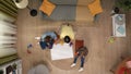 Top view of grandmother, adult daughter and grandson, white paper on the floor they have painted colorful palms.