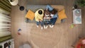 Top view of grandmother, adult daughter and kid sitting on the sofa, boy holding laptop and watching something together.