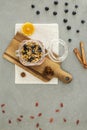 Top view on granola with berries on wooden desk next to orange.