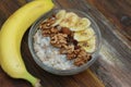 Top view of a Granola Bowl, Muesli with Oats, Nuts and Dried Fruit on Wooden table. Bannana, nuts, fruits. Healthy Breakfast. Diet