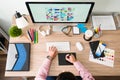 Top view of a graphic designer working at his office desk