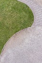 Top view of gray cobblestone pavement footpath with green grass Royalty Free Stock Photo