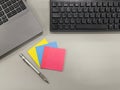 Top view of a gray desk in an office with a black computer keyboard, a laptop keyboard, a mechanical pencil and three packets of Royalty Free Stock Photo