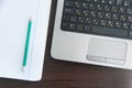 Top view of gray laptop and blank notebook page with pencil, on a wooden office table. Pencil and gadgets. Top view. Working or Royalty Free Stock Photo