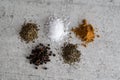 Top view of a gray surface with small piles of spices and seasonings Royalty Free Stock Photo