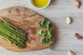 Top view of green asparaguses with a bowl of yolk and other ingredients on a wooden board Royalty Free Stock Photo