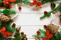 top view, green branches of spruce together with New Year& x27;s toys and bows on a white wooden background