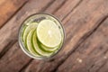 Top view green lime sliced in the soda water and glass place on the wooden table Royalty Free Stock Photo