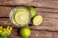 Top view green lime sliced in the soda water and glass place on the wooden table with yellow flowers Royalty Free Stock Photo