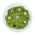 Top view of green long pasta with parsley, hazelnuts and seeds in plate isolated on a white
