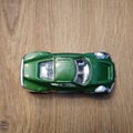 Top view of a green Mattel Hot Wheels toy car on a wooden surface