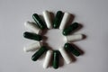 Top view of green multivitamins and white magnesium capsules in a shape of sun Royalty Free Stock Photo