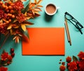 Top view for green pastel paper color decorated with blank empty orange paper, cup of coffee, glasses, colorful pencils and