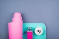 Top view of pink green yoga mat,glass water bottle and twisted white belt on grey background.