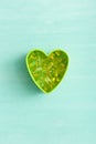 Top view on green plastic heart shape with pile of capsules Omega 3 on turquoise background. fish fat oil capsules Royalty Free Stock Photo