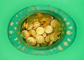 Top view of green Saint Patricks Day hat full of gold coins on green background Royalty Free Stock Photo