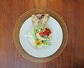 Top view of green salad with comestible flowers and bread