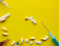 Green syringe with a needle and open yellow-white capsule with powder on a yellow background Royalty Free Stock Photo