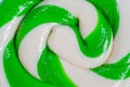 Top view: green and white large spiral candy lollipop - close up