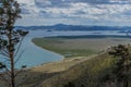 Top view on green yellow coast of bay blue Baikal lake. Dead trees bare trunks after fire on slope of mountain.Green pine. Siberia Royalty Free Stock Photo