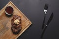 Top view of grilled bbq smoked meat steak with sauce on dark wooden board on black background, flat lay, copy space Royalty Free Stock Photo