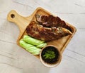 Top view of Grilled pork ribs, sliced cucumber and spicy sauce on wooden tray. Royalty Free Stock Photo