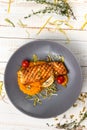 Top view grilled salmon steak with creamy pumpkin puree, fried cherry tomatoes and thyme, lunch menu of national food restaurant