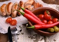 Top view of grilled sausages, chili peppers, pickled cucumbers and tomatoes Royalty Free Stock Photo