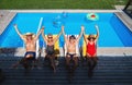 Top view of group of cheerful seniors sitting by swimming pool outdoors in backyard. Royalty Free Stock Photo