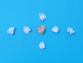 Top view of a group of crumpled paper on a blue paper background.