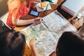 Top view of group of female students studying the map sitting at desk Royalty Free Stock Photo