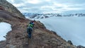 Top view of a group of hikers on snowy peaks of the mountains above the clouds