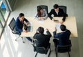 Top view of group of multiethnic busy people working in an office, Aerial view with businessman and businesswoman sitting around a Royalty Free Stock Photo