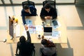 Top view of group of multiethnic busy people working in an office, Aerial view with businessman and businesswoman sitting around a Royalty Free Stock Photo