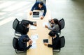 Top view of group of multiethnic busy people working in an office, Aerial view with businessman and businesswoman sitting around a Royalty Free Stock Photo