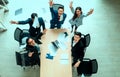 Top view of group of multiethnic busy people working in an office, Aerial view with businessman and businesswoman sitting around a Royalty Free Stock Photo