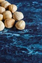 Top view of a group of peeled hazelnuts on blue marble background